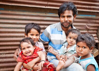 Parent caring for young children in a community, demonstrating the importance of family support and child wellbeing programmes.