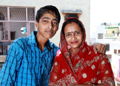 Mother and child standing together at home, illustrating the importance of family support and child-focused charitable programmes