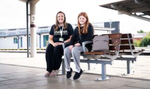 Railway Children staff member sitting with a young person at a railway station as part of the charity’s work supporting young people.
